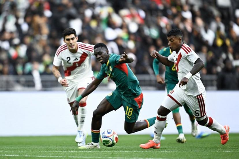 Senegal's forward #18 Ismaila Sarr (C) fight Peru's defender #05 Miguel Araujo (R) during the international friendly football match between Senegal and Peru at the Stade de France in Saint-Denis, north of Paris, on March 28, 2026.   JULIEN DE ROSA / AFP