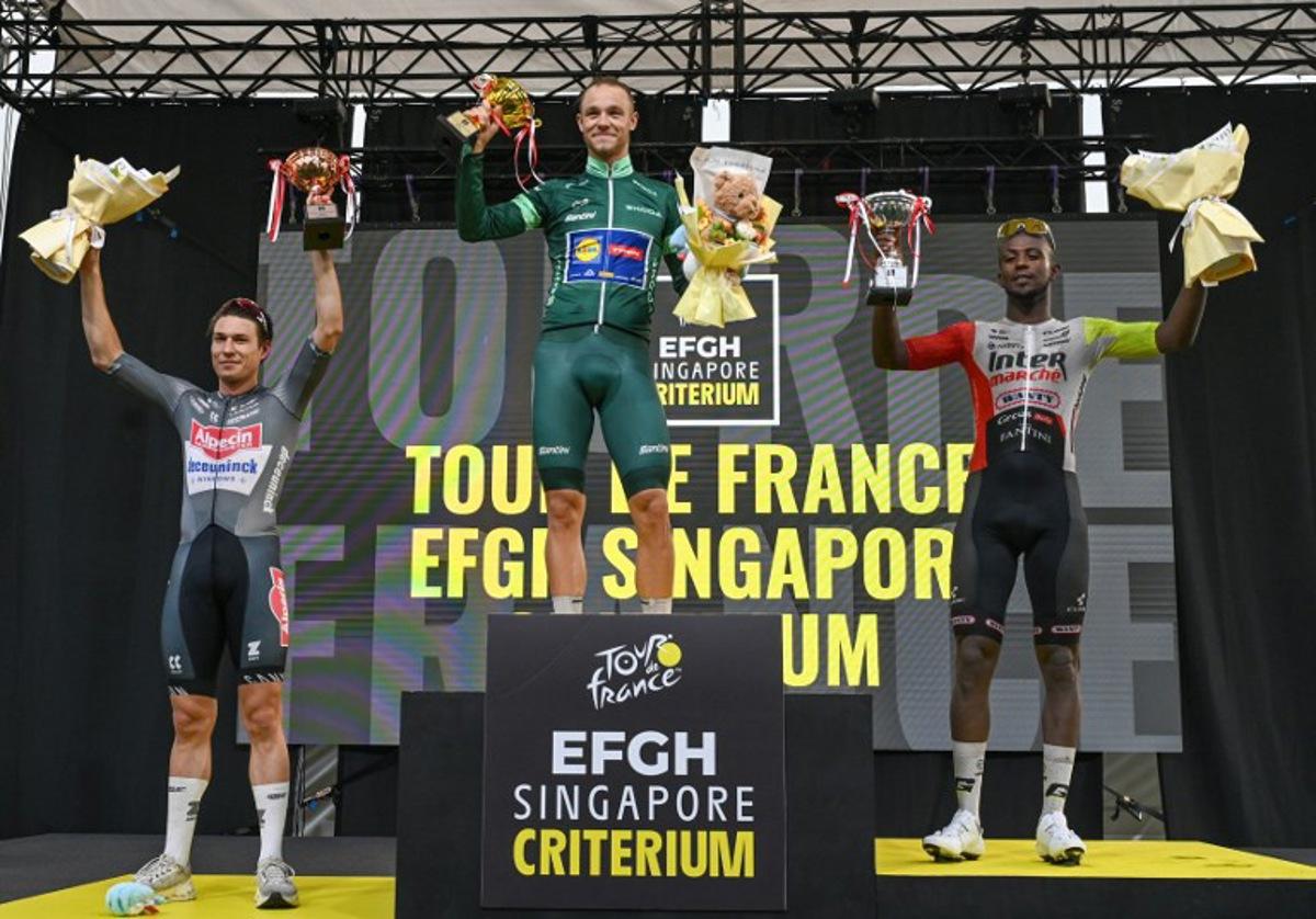(L-R) Alpecin team's Belgian rider Jasper Philipsen, Lidl - Trek team's Italian rider Jonathan Milan and Intermarche - Wanty team's Eritrean rider Biniam Girmay celebrate on the podium after the 4th Tour de France Singapore Criterium race in Singapore on November 2, 2025.  Roslan RAHMAN / AFP