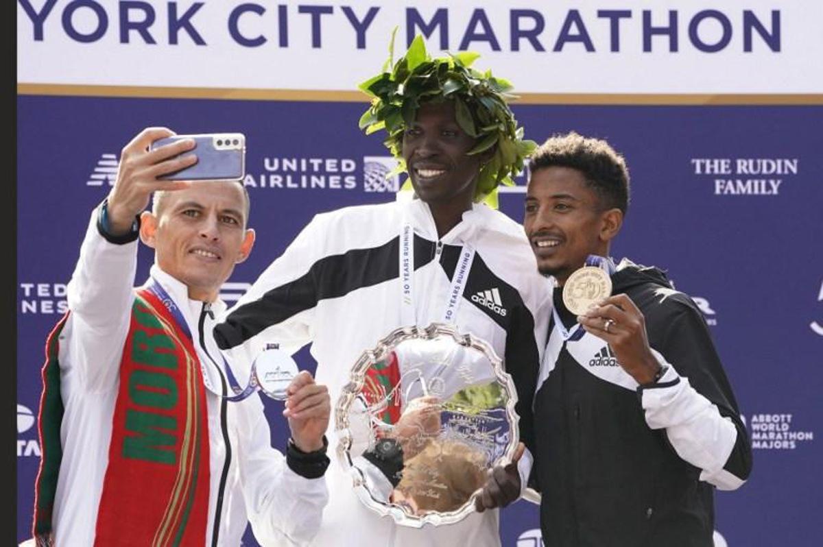 Men's division winners Albert Korir Kenya (C), 2nd place winner  Mohamed Reda El Aaraby of Morocco (L), and 3rd place winner Eyob Faniel of Italy pose on the podium after the 2021 TCS New York City Marathon in New York on November 7, 2021. After a forced break in 2020, the New York City Marathon is back on for its 50th edition, and with it the countless opportunities to run it for charity, an industry that has become a staple, and hopes to take off again after the pandemic. TIMOTHY A. CLARY / AFP