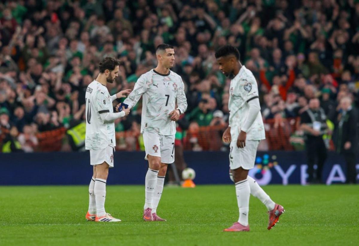 Portugal's forward Cristiano Ronaldo hands the captain's armband to Portugal's midfielder Bernardo Silva (L) as he leaves the pitch after receiving a second yellow card during the men's football 2026 World Cup Group F qualifier between Ireland and Portugal at Aviva Stadium in Dublin on November 13, 2025.  Paul Faith / AFP