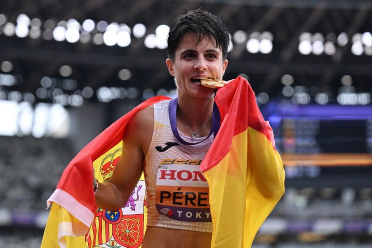 Gold medallist Spain's athlete Maria Perez celebrates with her medal and her country's flag winning the women's 20km race walk final during the World Athletics Championships in Tokyo on September 20, 2025.  Jewel SAMAD / AFP