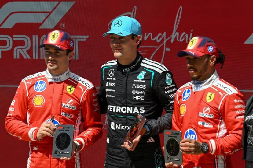 Mercedes' British driver George Russell (C) celebrates winning next to second-placed Ferrari's Monegasque driver Charles Leclerc (L) and third-placed Ferrari's British driver Lewis Hamilton (R) after the sprint race ahead of the Formula One Chinese Grand Prix at the Shanghai International Circuit in Shanghai on March 14, 2026.  JADE GAO / AFP