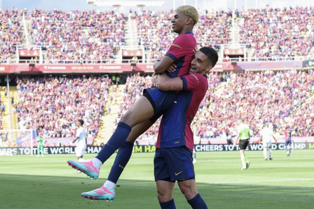 Barcelona's Spanish forward #19 Lamine Yamal celebrates scoring his team's second goal with Barcelona's Spanish forward #07 Ferran Torres during the Spanish league football match between FC Barcelona and Real Madrid CF at Estadi Olimpic Lluis Companys in Barcelona, on May 11, 2025.  LLUIS GENE / AFP