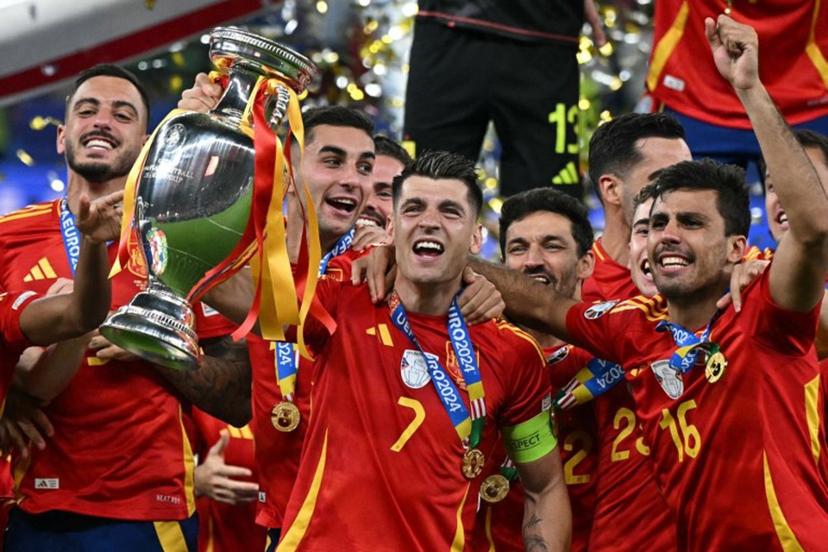 Spain's forward #07 Alvaro Morata rises the trophy next to Spain's midfielder #16 Rodri (R) after winning the UEFA Euro 2024 final football match between Spain and England at the Olympiastadion in Berlin on July 14, 2024.  JAVIER SORIANO / AFP