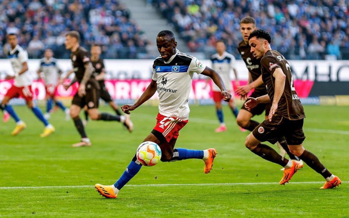 Hamburg's French forward Jean-Luc Dompe (L) and Sankt Pauli's Greek defender Manolis Saliakas vie for the ball during the second division football match Hamburger SV vs St Pauli in Hamburg on April 21, 2023.   Axel Heimken / AFP