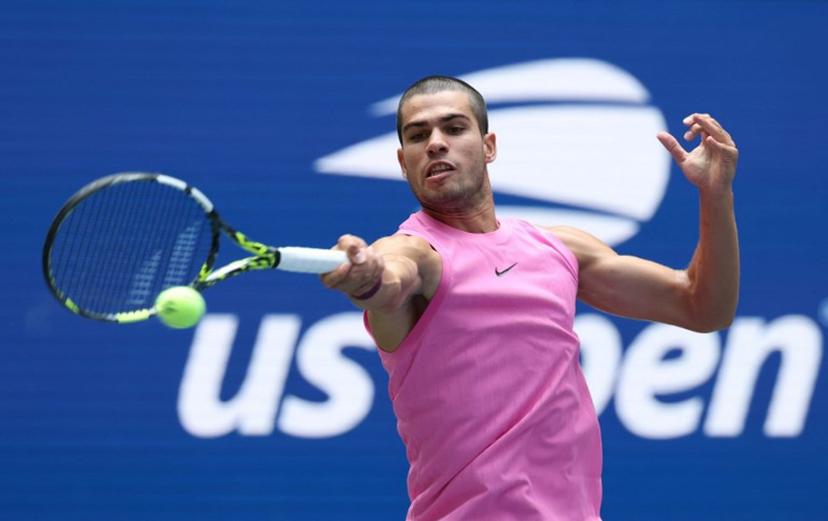 Spain's Carlos Alcaraz hits a return to Italy's Luciano Darderi during their men's singles third round match on day six of the US Open tennis tournament at the USTA Billie Jean King National Tennis Center in New York City on August 29, 2025.  TIMOTHY A. CLARY / AFP