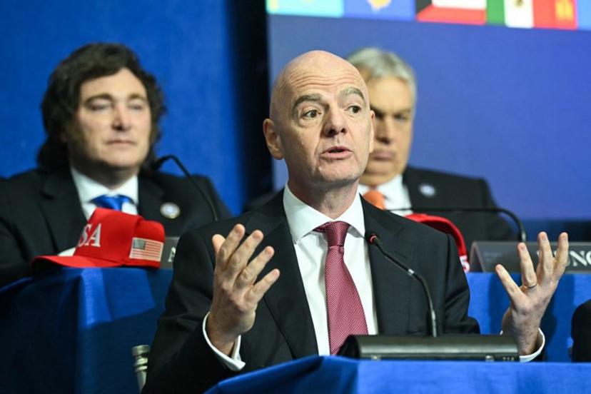 (L/R) Argentina's President Javier Milei looks on as FIFA President Gianni Infantino speaks during the inaugural meeting of the "Board of Peace" hosted by US President Donald Trump at the US Institute of Peace in Washington, DC, on February 19, 2026. President Trump on Thursday gathers allies to inaugurate the "Board of Peace," his new institution focused on progress on Gaza but whose ambitions reach much further. Around two dozen world leaders or other senior officials have come to Washington for the meeting -- including several of Trump's authoritarian-leaning friends and virtually none of the European democrats that traditionally sign on to US initiatives.  SAUL LOEB / AFP