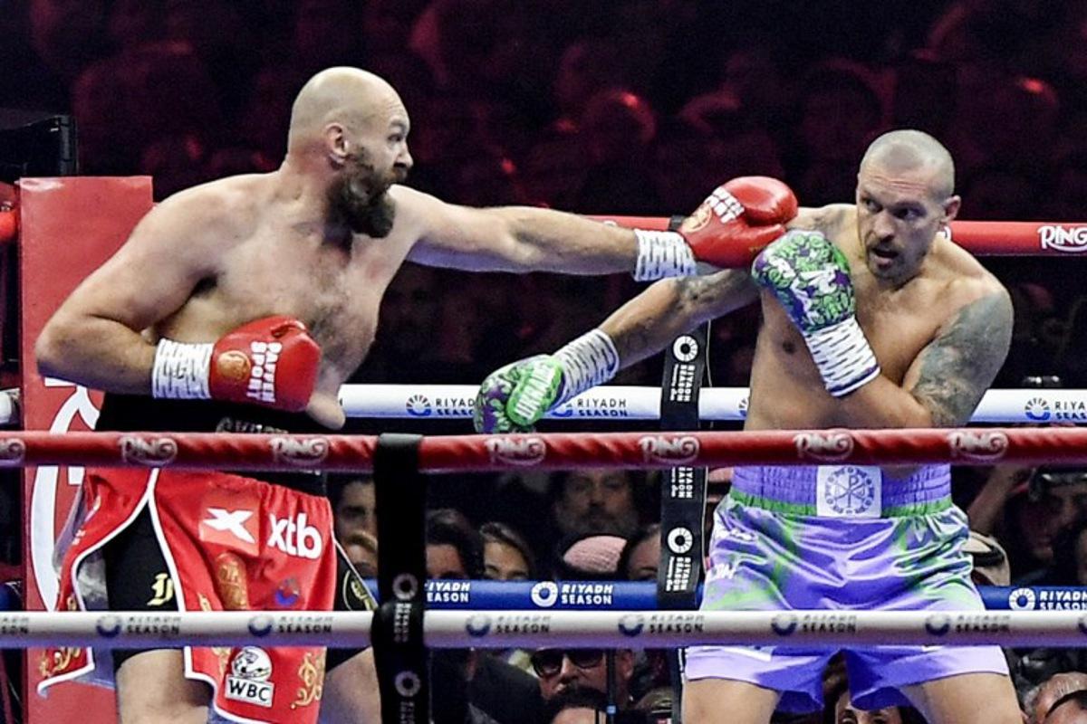 Britain's Tyson Fury (red) and Ukraine's Oleksandr Usyk (blue) compete during their heavyweight world championship rematch at the Kingdom Arena in Riyadh on December 22, 2024.  AFP