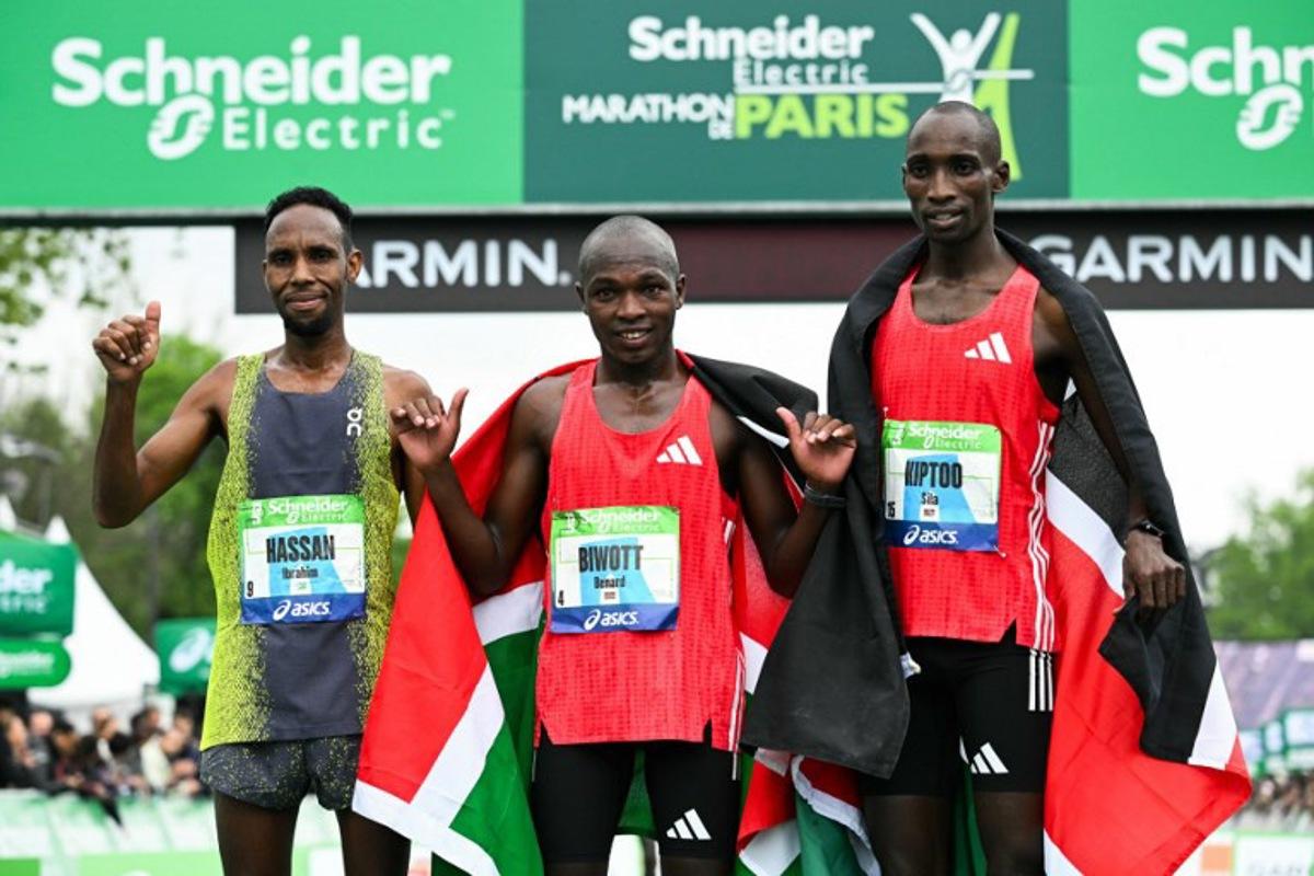 (From L) Second-placed Djibouti's Ibrahim Hassan, winner Kenya's Benard Biwott and third-placed Kenya's Sila Kiptoo pose after crossing the finish line in the men's Paris Marathon, in Paris, on April 13, 2025.  Bertrand GUAY / AFP