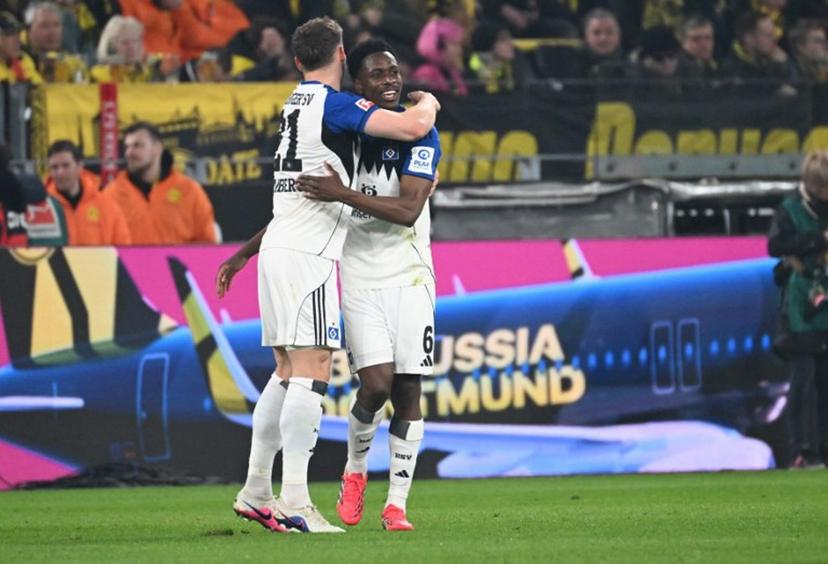 Hamburg's Belgian-Congolese midfielder #06 Albert Sambi Lokonga (R) celebrates his 0-2 during the German first division Bundesliga football match between Borussia Dortmund and HSV Hamburg in Dortmund, western Germany, on March 21, 2026.  UWE KRAFT / AFP