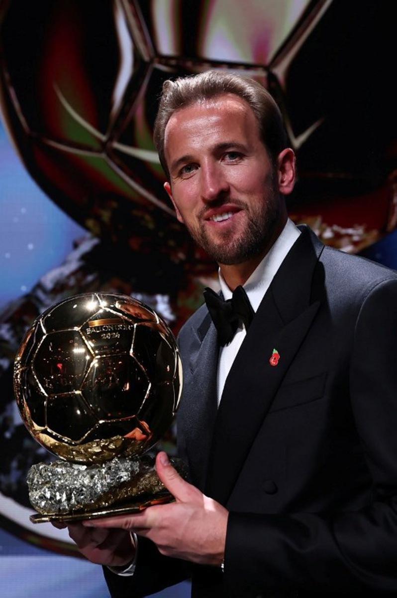 England and Bayern Munich forward Harry Kane poses with his trophy on stage after receiving the Ballon d'Or award for the best male footballer during the 2026 Ballon d'Or France Football award ceremony at the Palladium Theatre in London on October 26, 2026.  Franck FIFE / AFP
