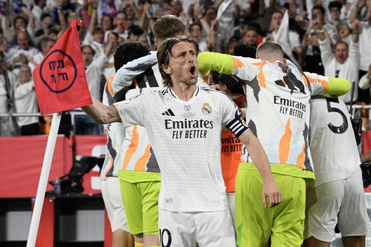 Real Madrid's Croatian midfielder #10 Luka Modric and teammates celebrate their second goal scored by Real Madrid's French midfielder #14 Aurelien Tchouameni during their Spanish Cup, Copa del Rey (King's Cup) final football match between FC Barcelona and Real Madrid CF at La Cartuja stadium in Seville on April 26, 2025.  Josep LAGO / AFP