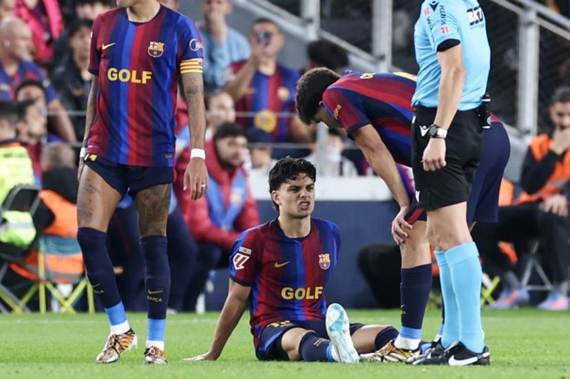 Barcelona's Spanish defender #12 Xavi Espart sits on the pitch after sustaining an injury during the Spanish league football match between FC Barcelona and Real Madrid CF at Camp Nou Stadium in Barcelona on October 25, 2026.  Josep LAGO / AFP