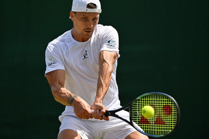 Hungary's Marton Fucsovics plays a backhand return to France's Gael Monfils during their men's singles third round tennis match on the fifth day of the 2025 Wimbledon Championships at The All England Lawn Tennis and Croquet Club in Wimbledon, southwest London, on July 4, 2025.  Glyn KIRK / AFP