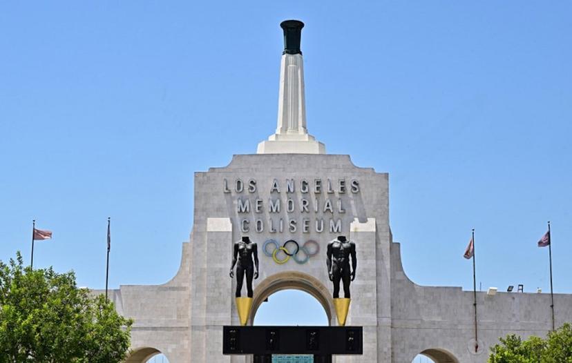 Flags fly in the wind at the Los Angeles Memorial Coliseum on July 18, 2024 in Los Angeles, California. Los Angeles will become a three-time Summer Olympic host city after hosting the 2028 Summer Olympics. Frederic J. BROWN / AFP