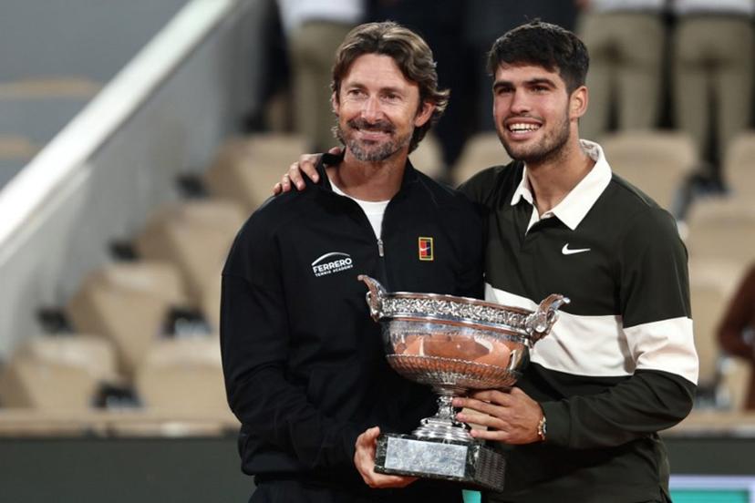Spain's Carlos Alcaraz poses with his Spanish coach Juan Carlos Ferrero (L) after winning against Italy's Jannik Sinner at the end of their men's singles final match on day 15 of the French Open tennis tournament on Court Philippe-Chatrier at the Roland-Garros Complex in Paris on June 8, 2025.  Thibaud MORITZ / AFP
