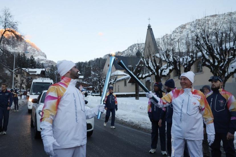 Torchbearers take part in the relay of the Olympic flame in Cortina d'Ampezzo on January 26, 2026.   Odd ANDERSEN / AFP