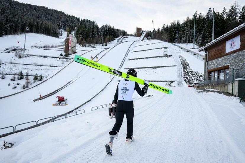 A young athlete walks next to the ski jump in Courchevel, which is set to host the ski jumping competitions at the 2030 Winter Olympics, in Courchevel La Praz, central-eastern France on December 2, 2025.  ARNAUD FINISTRE / AFP