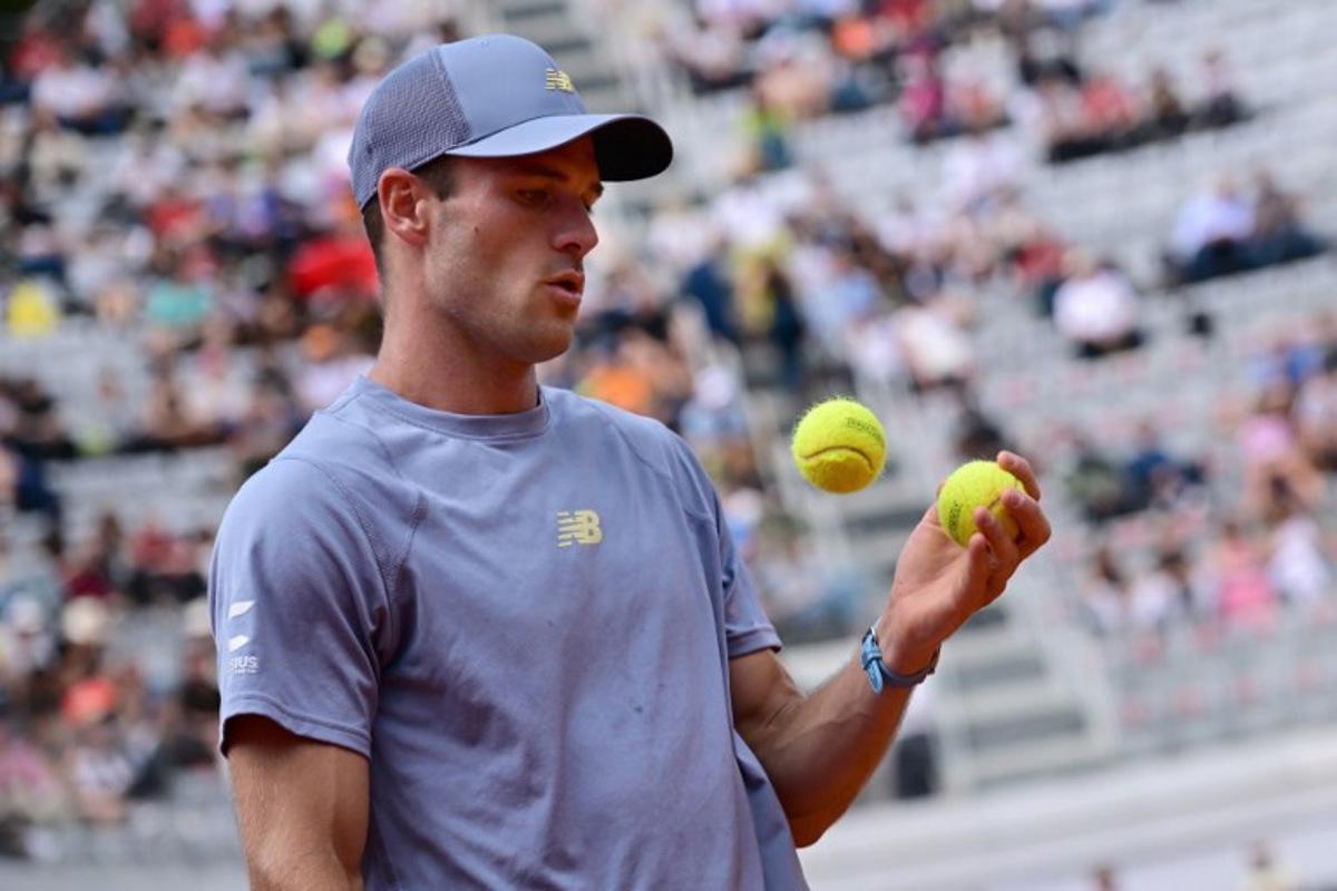 USA's Tommy Paul chooses a ball before serving during the men's singles quarter-final match against Poland's Hubert Hurkacz at the ATP Rome Open tennis tournament at Foro Italico in Rome on May 15, 2025.   Piero CRUCIATTI / AFP
