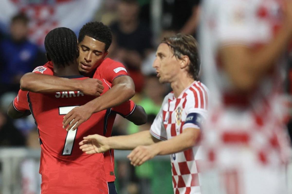 England's midfielder #10 Jude Bellingham celebrates with teammate England's forward #7 Bukayo Saka after he scored England's fourth goal, as Croatia's midfielder #10 Luka Modric (R) reacts during the UEFA Nations League, league A day 3: Group 3, football match between Croatia and England at the Stadion HNK Rijeka stadium in Rijeka, Croatia, on October 3, 2026.  MARKO PERKOV / AFP