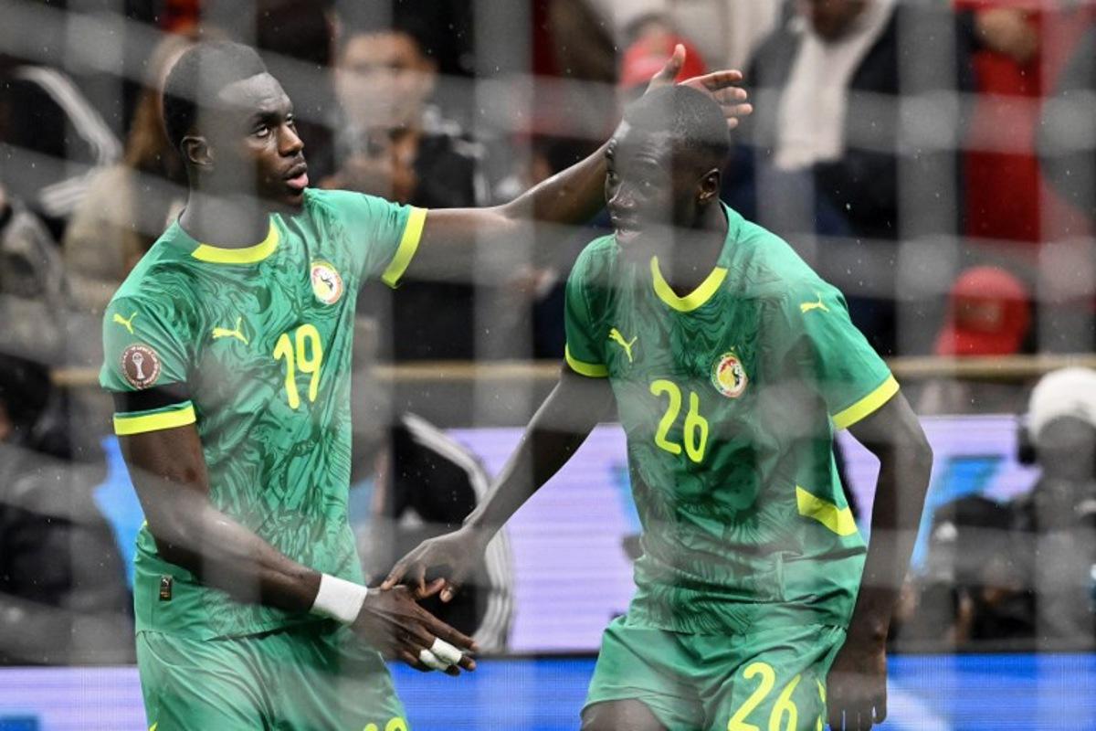 Senegal's defender #19 Moussa Niakhate congratulates Senegal's midfielder #26 Pape Gueye during the Africa Cup of Nations (CAN) final football match between Senegal and Morocco at the Prince Moulay Abdellah Stadium in Rabat on January 18, 2026.   SEBASTIEN BOZON / AFP