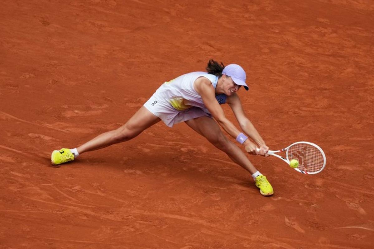 Poland's Iga Swiatek plays a backhand return to Kazakhstan's Elena Rybakina during their women's singles match on day 8 of the French Open tennis tournament on Court Philippe-Chatrier at the Roland-Garros Complex in Paris on June 1, 2025.  Dimitar DILKOFF / AFP