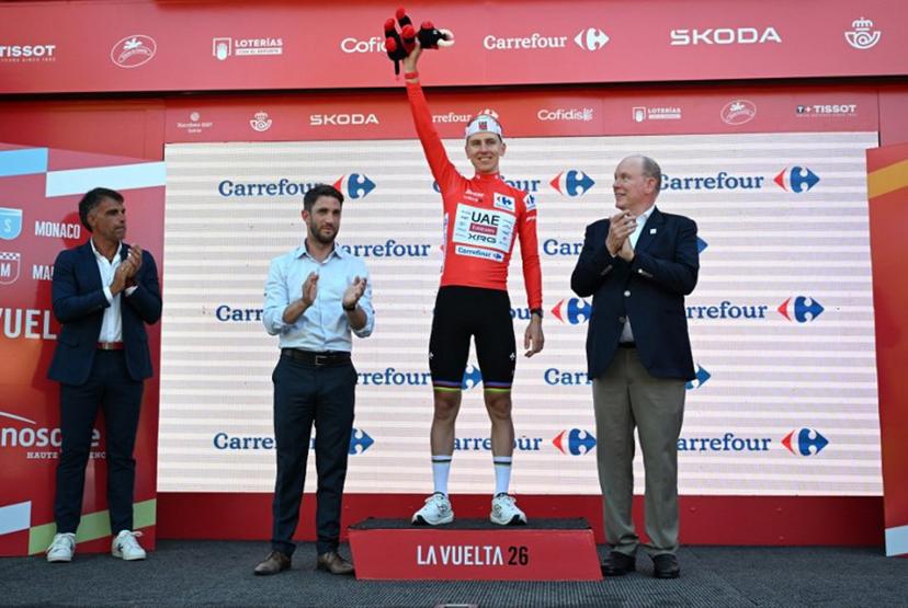 UAE Team Emirates - XRG team's Slovenian rider Tadej Pogacar celebrates on the podium wearing the overall leader's red jersey flanked by (from R) Prince's Albert II of Monaco, Manosque's mayor Camille Galtier and Spanish former Tour de France winner Oscar Pereiro after the second stage of the Vuelta a Espana 2026, a 214,3 km race between Monaco and Manosque on August 23, 2026.  Miguel MEDINA / AFP