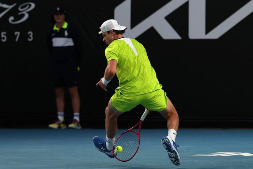 Belgium's Zizou Bergs hits a shot between his legs against Poland's Hubert Hurkacz during their men's singles match on day three of the Australian Open tennis tournament in Melbourne on January 20, 2026.  IZHAR KHAN / AFP