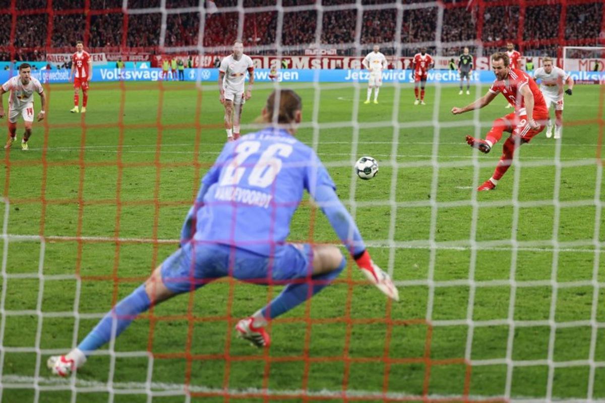 Bayern Munich's English forward #09 Harry Kane (R) scores the opening goal from the penalty spot past Leipzig's Belgian goalkeeper #26 Maarten Vandevoordt during the German Cup (DFB-Pokal) quarter-final football match between FC Bayern Munich and RB Leipzig in Munich, southern Germany on February 11, 2026.  Alexandra BEIER / AFP