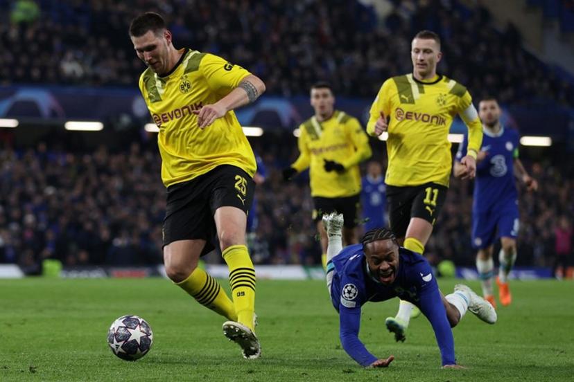 Chelsea's English midfielder Raheem Sterling (C) falsl to the ground after chalenging Dortmund's German defender Niklas Sule (L) during the UEFA Champions League round of 16 second-leg football match between Chelsea and Borrusia Dortmund at Stamford Bridge in London on March 7, 2023.  ADRIAN DENNIS / AFP