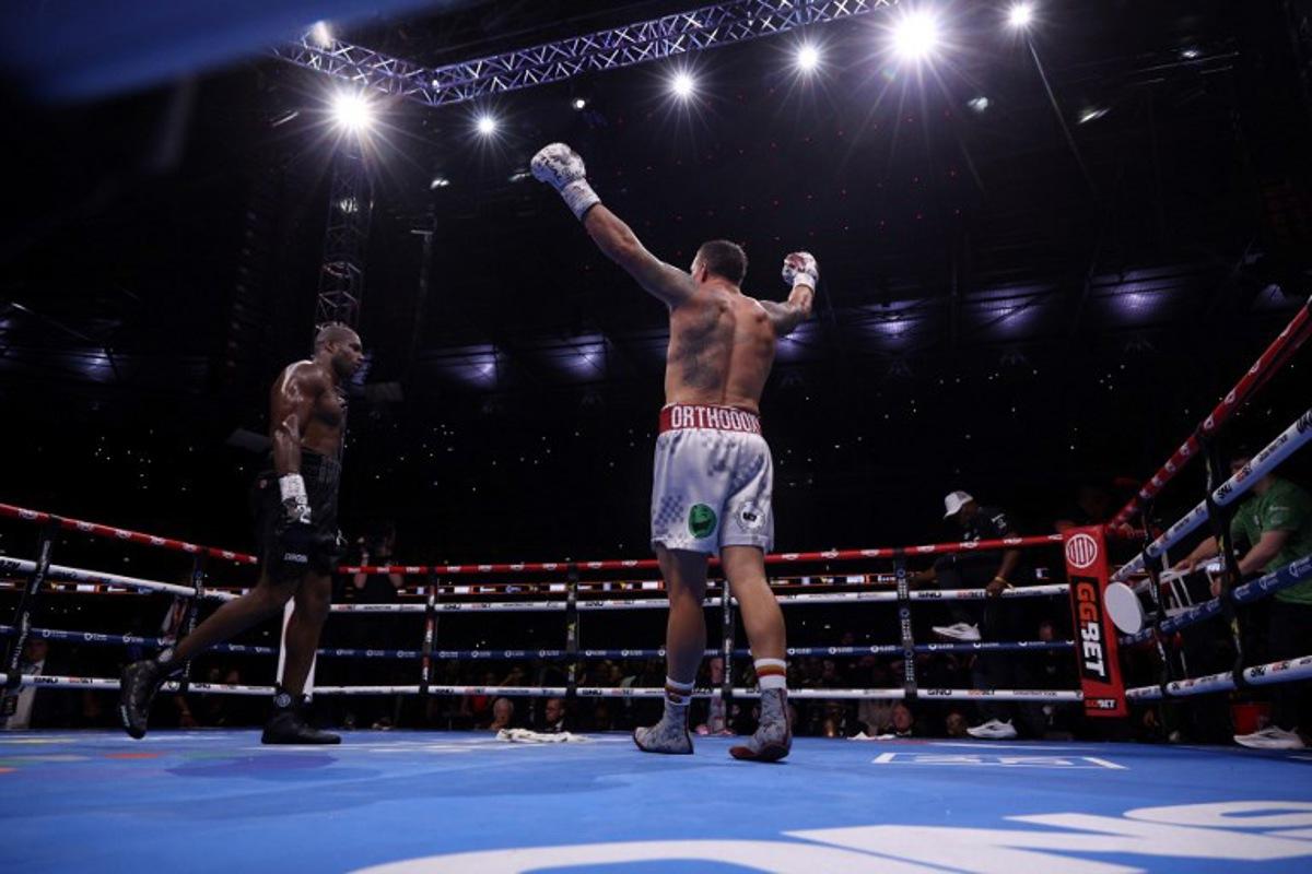 Ukraine's Oleksandr Usyk (R) celebrates defeating Britain's Daniel Dubois in their undisputed world heavyweight boxing title bout at Wembley Stadium in London on July 19, 2025.  Adrian Dennis / AFP