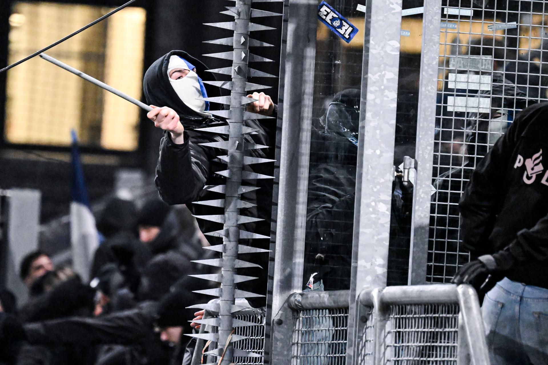 A masked Genk supporter provokes Dutch police ahead of a soccer game between Dutch soccer club FC Utrecht and Belgian KRC Genk, on Thursday 22 January 2026 in Utrecht, Netherlands, the seventh game (out of 8) in the league phase of the UEFA Europa League competition. BELGA PHOTO TOM GOYVAERTS