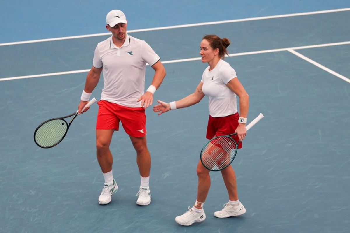 Poland's Jan Zielinski (L) and Katarzyna Kawa react after a match point against Netherlands' David Pel and Demi Schuurs in their mixed doubles match at the United Cup tennis tournament in Sydney on January 7, 2026.  Izhar KHAN / AFP