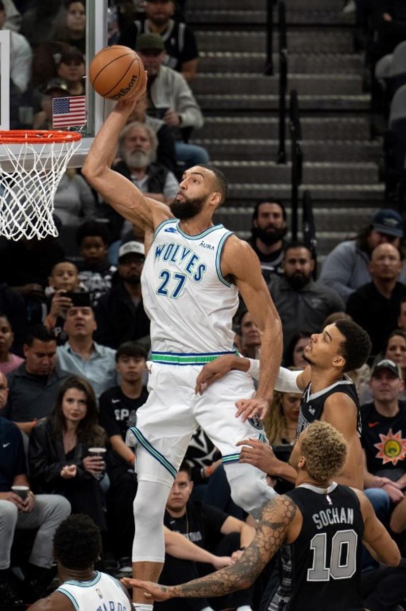 Minnesota Timberwolves' French center #27 Rudy Gobert (L) makes a dunk as San Antonio Spurs' French forward #01 Victor Wembanyama looks on during the NBA game between the San Antonio Spurs and the Minnesota Timberwolves at the Frost Bank Center in San Antonio, Texas, on January 27, 2024.  SUZANNE CORDEIRO / AFP