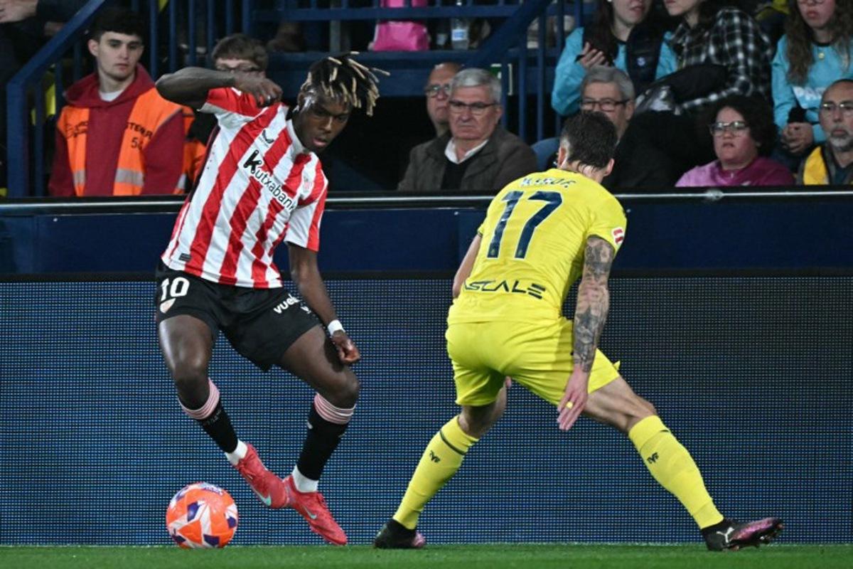 Athletic Bilbao's Spanish forward #10 Nico Williams and Villarreal's Spanish defender #17 Kiko Femenia vie for the ball during the Spanish league football match between Villarreal CF and Athletic Club Bilbao at La Ceramica stadium in Vila-real on April 6, 2025.  JOSE JORDAN / AFP