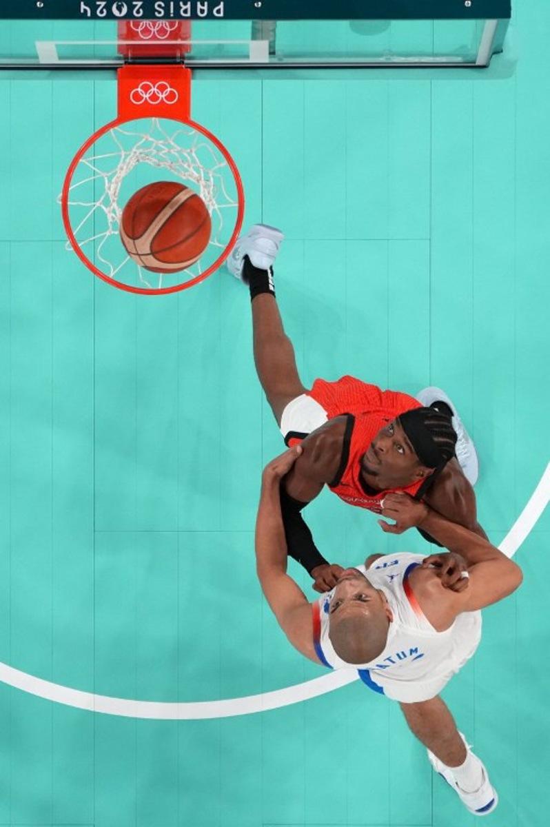 An overview shows France's #05 Nicolas Batum (Bottom) and Canada's #02 Shai Gilgeous-Alexander eye the ball in the men's quarterfinal basketball match between France and Canada during the Paris 2024 Olympic Games at the Bercy Arena in Paris on August 6, 2024.  Evelyn HOCKSTEIN / POOL / AFP
