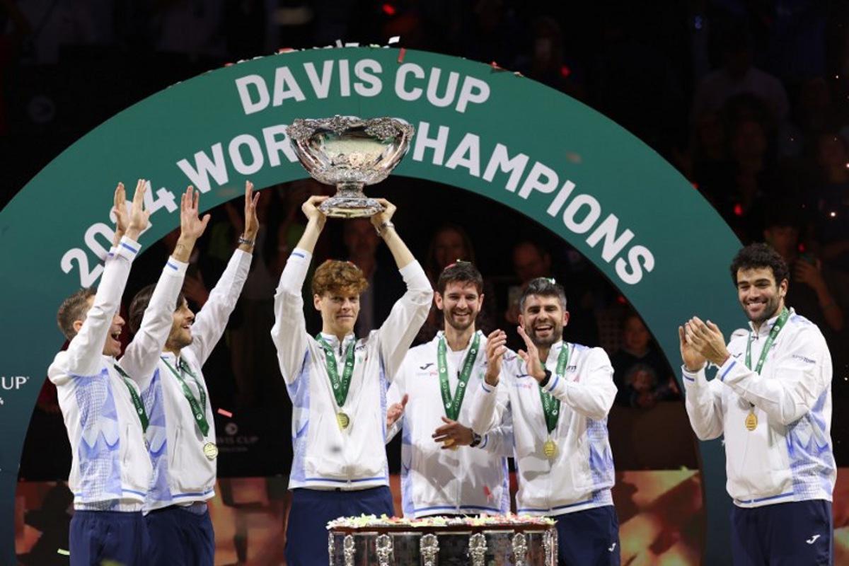 Italy's Jannik Sinner raises the trophy with teammates after winning the Davis Cup Finals at the Palacio de Deportes Jose Maria Martin Carpena arena in Malaga, southern Spain, on November 24, 2024.  Thomas COEX / AFP