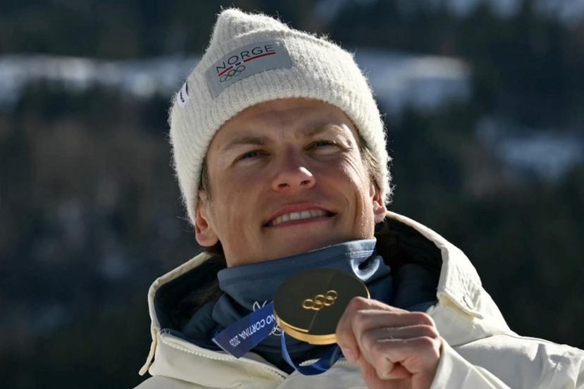 Gold medallist Norway's Johannes Hoesflot Klaebo celebrates on the podium for the men's team cross country free sprint final event of the Milano Cortina 2026 Winter Olympic Games at Tesero Cross-Country Skiing Stadium in Lago di Tesero (Val di Fiemme), on February 18, 2026.  Javier SORIANO / AFP