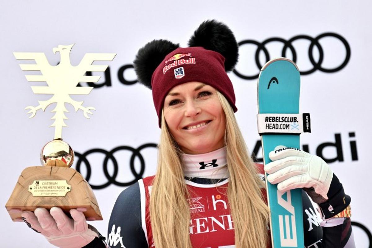 Third-placed US Lindsey Vonn holds her trophy as she celebrates on the podium of the women's Super G event during the FIS Alpine Ski World Cup 2025-2026, in Val d'Isere, southwestern France, on December 21, 2025.  Jeff PACHOUD / AFP