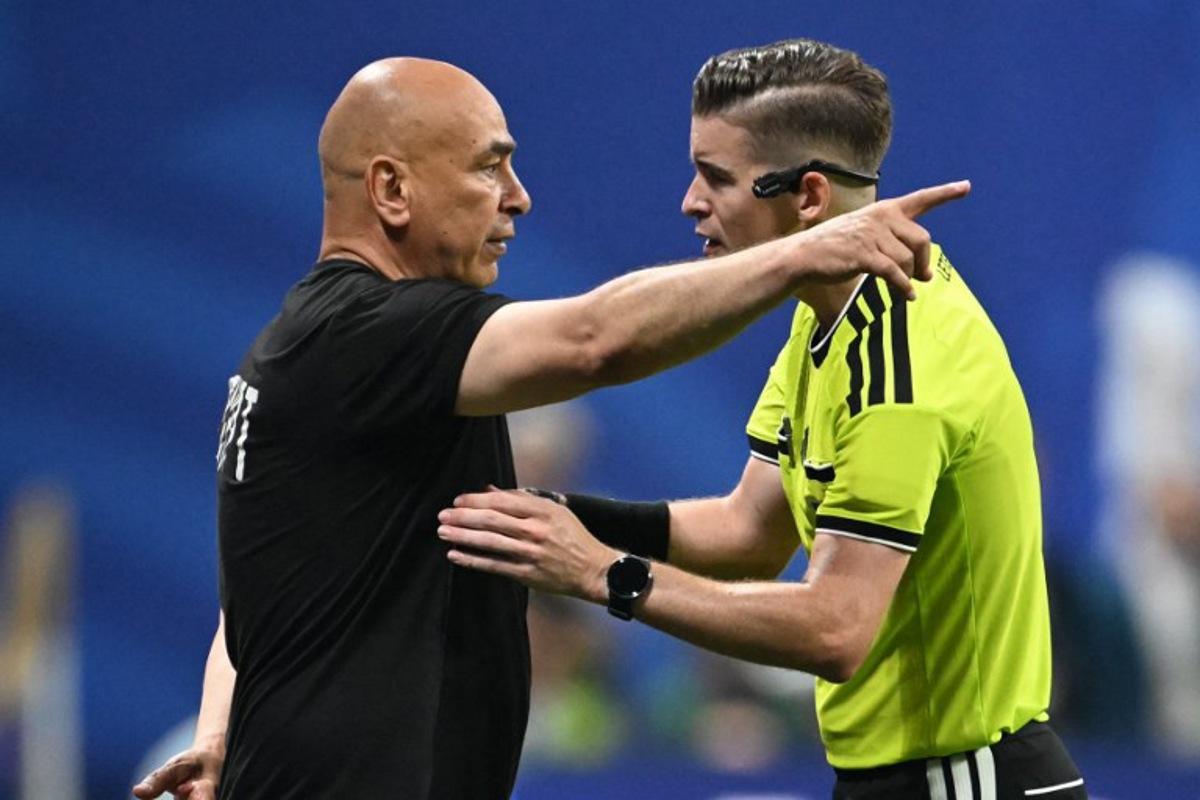 Egypt's head coach Hossam Hassan speaks with French referee Francois Letexier during the 2026 World Cup round of 16 football match between Argentina and Egypt at Atlanta Stadium in Atlanta on July 7, 2026.   ROBERTO SCHMIDT / AFP