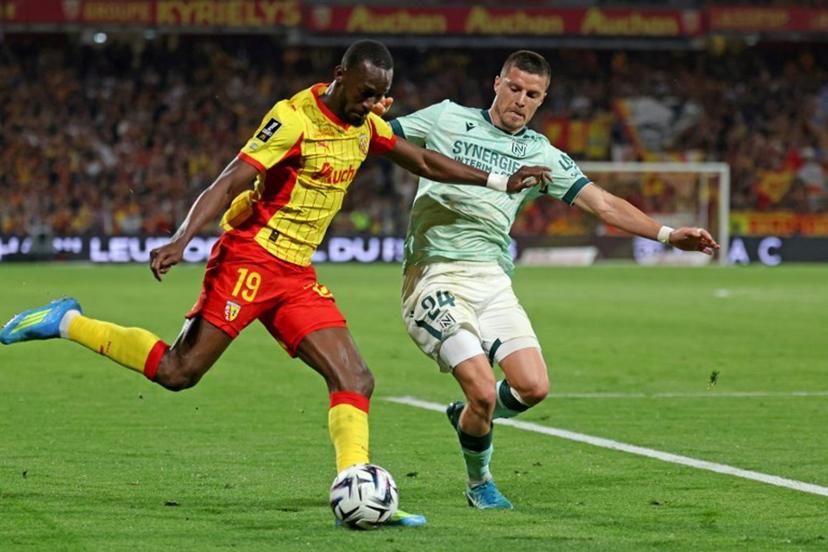 Lens' Senegalese forward #19 Abdallah Sima (L) and Nantes' French defender #24 Frederic Guilbert fight for the ball during the French L1 football match between RC Lens and FC Nantes at the Stade Bollaert-Delelis stadium in Lens on May 8, 2026.  Francois LO PRESTI / AFP