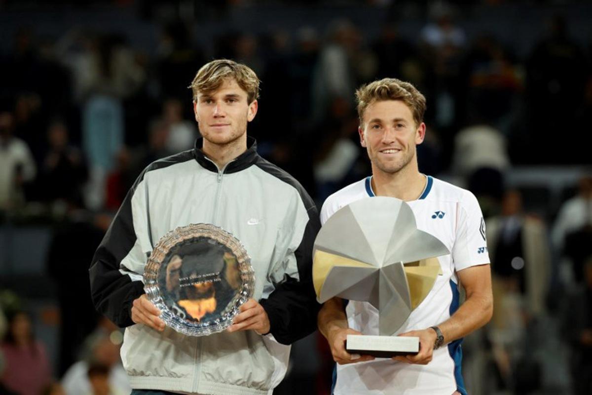 Winner Norway's Casper Ruud (R) and Britain's Jack Draper pose with their trophies at the end of their 2025 ATP Tour Madrid Open tennis tournament singles final match at the Caja Magica in Madrid, on May 4, 2025.  OSCAR DEL POZO / AFP