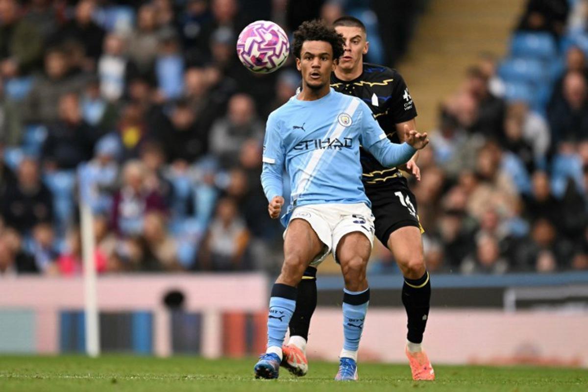 Manchester City's Norwegian midfielder #52 Oscar Bobb battles for the ball with Everton's Ukrainian defender #16 Vitaliy Mykolenko during the English Premier League football match between Manchester City and Everton at the Etihad Stadium in Manchester, north west England, on October 18, 2025.  Oli SCARFF / AFP