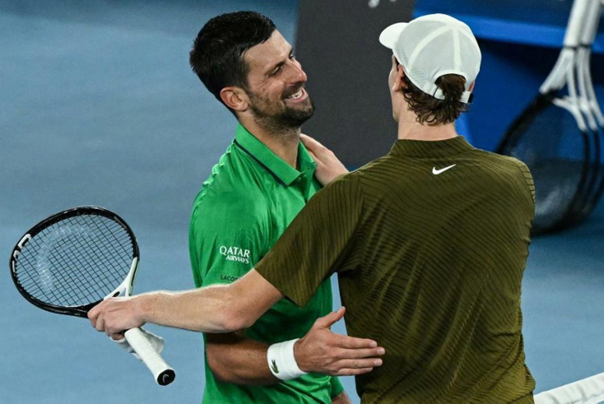 Serbia's Novak Djokovic greets Italy's Jannik Sinner after winning their men's singles semi-final match on day thirteen of the Australian Open tennis tournament in Melbourne on January 31, 2026.  WILLIAM WEST / AFP