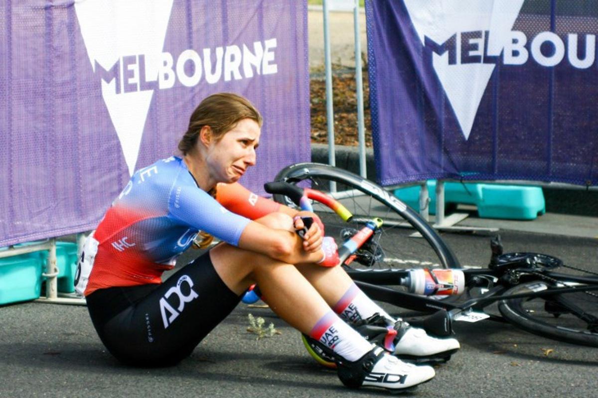 UAE Team Adq's Dominika Wlodarczyk of Poland collapses to the ground after finishing second in the the 2024 Women's Elite Cadel Evans Great Ocean Road Race cycling event in Geelong on January 27, 2024.  CHRIS PUTNAM / AFP