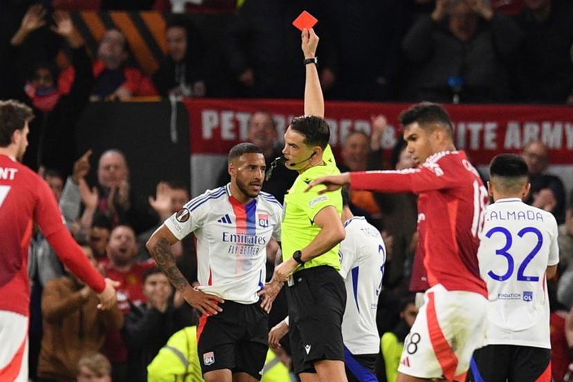 Swiss referee Sandro Scharer shows a red card to Lyon's French midfielder #08 Corentin Tolisso during the UEFA Europa league quarter-final final, second leg football match between Manchester United and Lyon at Old Trafford stadium in Manchester, north west England, on April 17, 2025.  Oli SCARFF / AFP