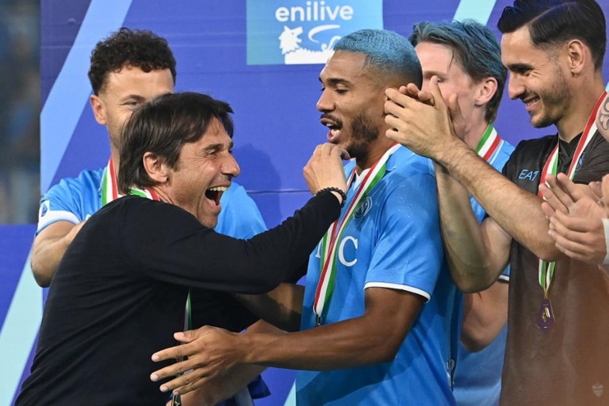 Napoli's Italian coach Antonio Conte (L) celebrates with Napoli's Brazilian defender #05 Juan Jesus during the trophy ceremony for the Italian Champions following the Italian Serie A football match between Napoli and Cagliari at the Diego Armando Maradona stadium in Naples on May 23, 2025.  Isabella BONOTTO / AFP