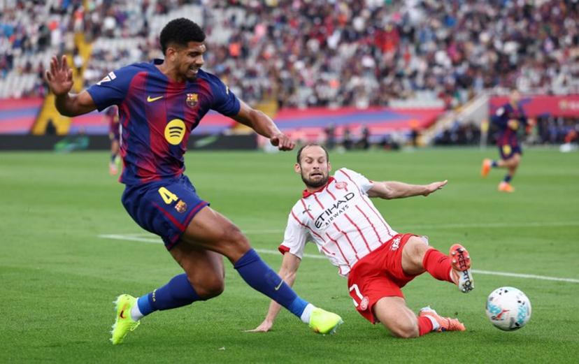 Barcelona's Uruguayan defender #04 Ronald Federico Araujo da Silva fights for the ball with Girona's Dutch defender #17 Daley Blind during the Spanish league football match between FC Barcelona and Girona FC at Estadi Olimpic Lluis Companys in Barcelona on October 18, 2025.  Josep LAGO / AFP