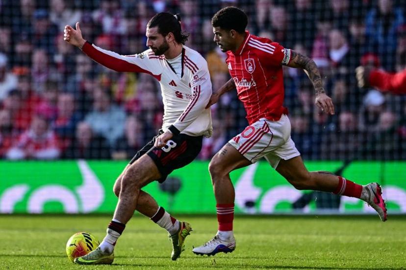 Nottingham Forest's English midfielder #10 Morgan Gibbs-White (R) pulls on the jersey of Liverpool's Hungarian midfielder #08 Dominik Szoboszlai (L) during the English Premier League football match between Nottingham Forest and Liverpool at The City Ground in Nottingham, central England on February 22, 2026.  Ben STANSALL / AFP