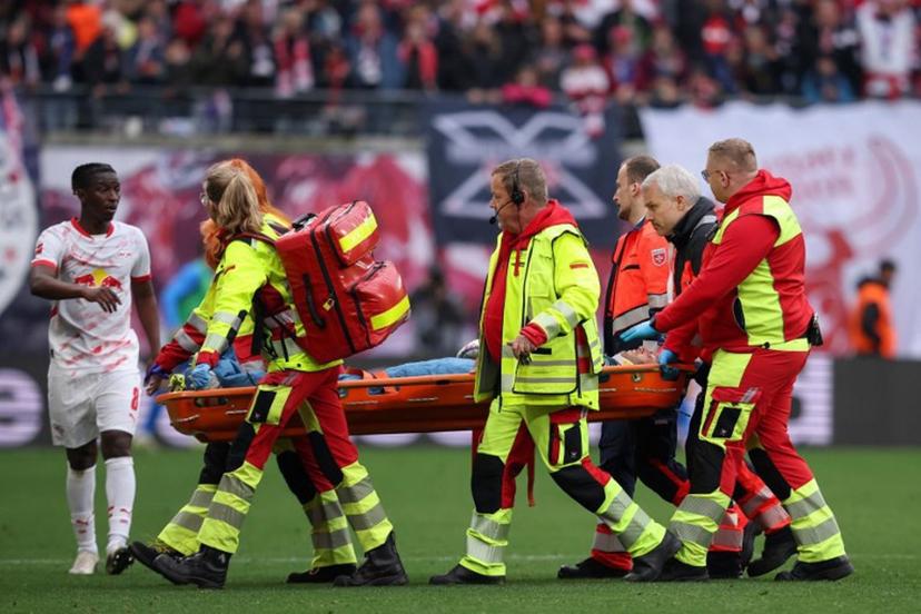 Leipzig's Malian midfielder #08 Amadou Haidara (L) checks on Leipzig's Hungarian goalkeeper #01 Peter Gulacsi who is stretchered off after sustaining an injury during the German first division Bundesliga football match between RB Leipzig and Holstein Kiel in Leipzig, eastern Germany on April 19, 2025.  RONNY HARTMANN / AFP